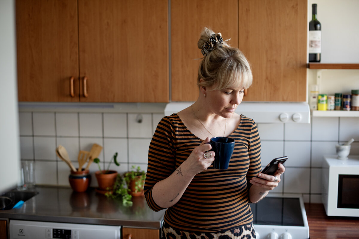 Kobieta w kuchni trzymająca telefon w ręku