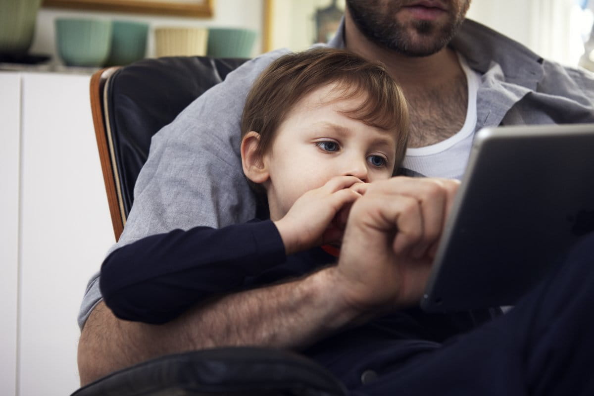 Chłopiec z ojcem oglądają coś wspólnie na ipadzie