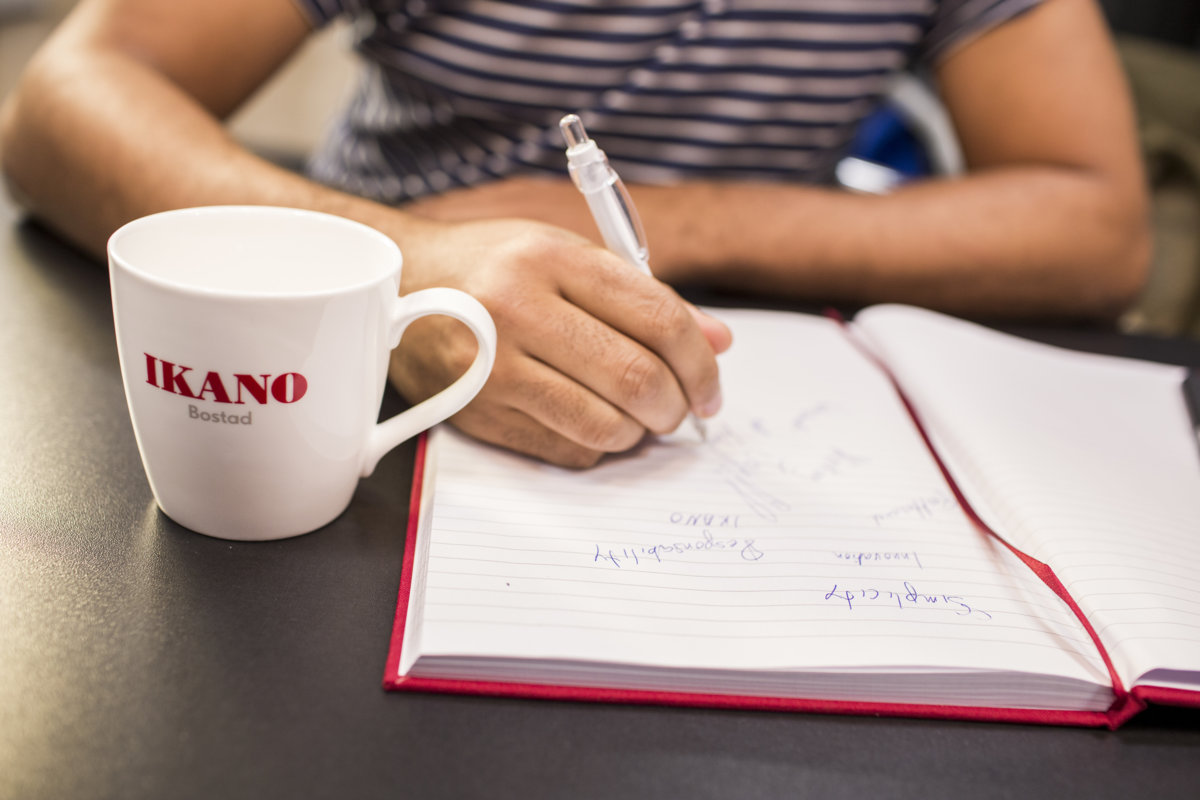 kobieta notuje informacje w notesie, na stole stoi kubek IKANO Banku