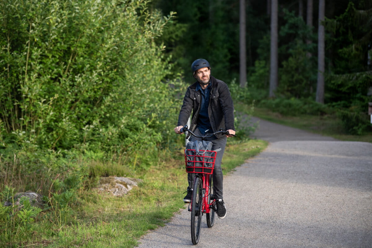 mężczyzna jedzie rowerem obok lasu