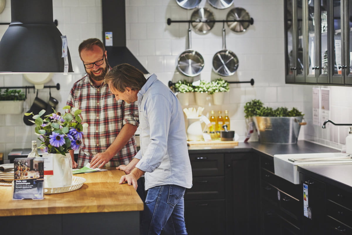 Mezczyzni w kuchni IKEA sprawdzają ratę kredytu