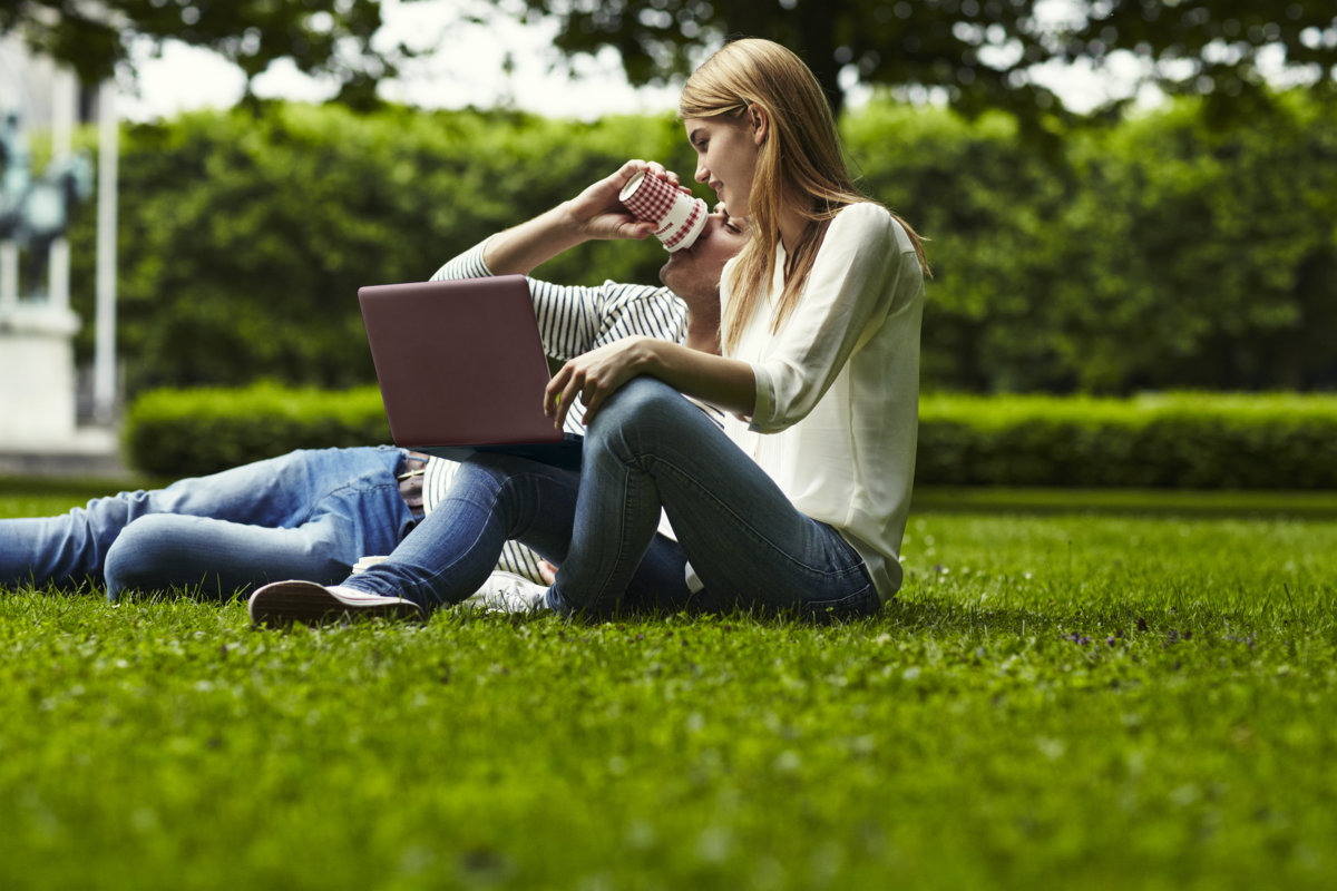 Para w parku siedzi na trawie